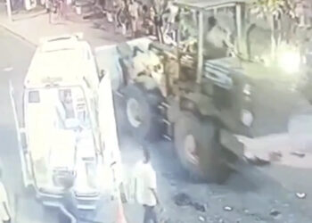 Homem em trator avança em direção aos foliões