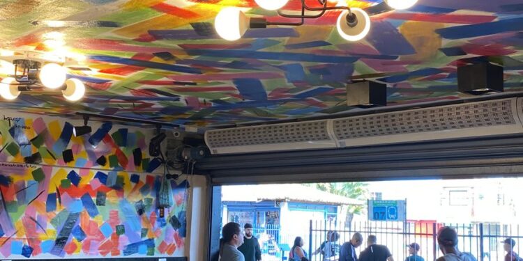 Artista local muda cenário de rodoviária com painel de cores