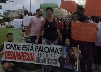 Pessoas com cartazes escritos: Onde está paloma? Desaparecida há 100 dias queremos respostas.