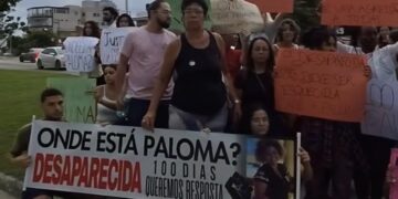 Pessoas com cartazes escritos: Onde está paloma? Desaparecida há 100 dias queremos respostas.